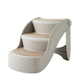 Foldable plastic pet ladder in beige colour with non-slip mat placed against a sofa.