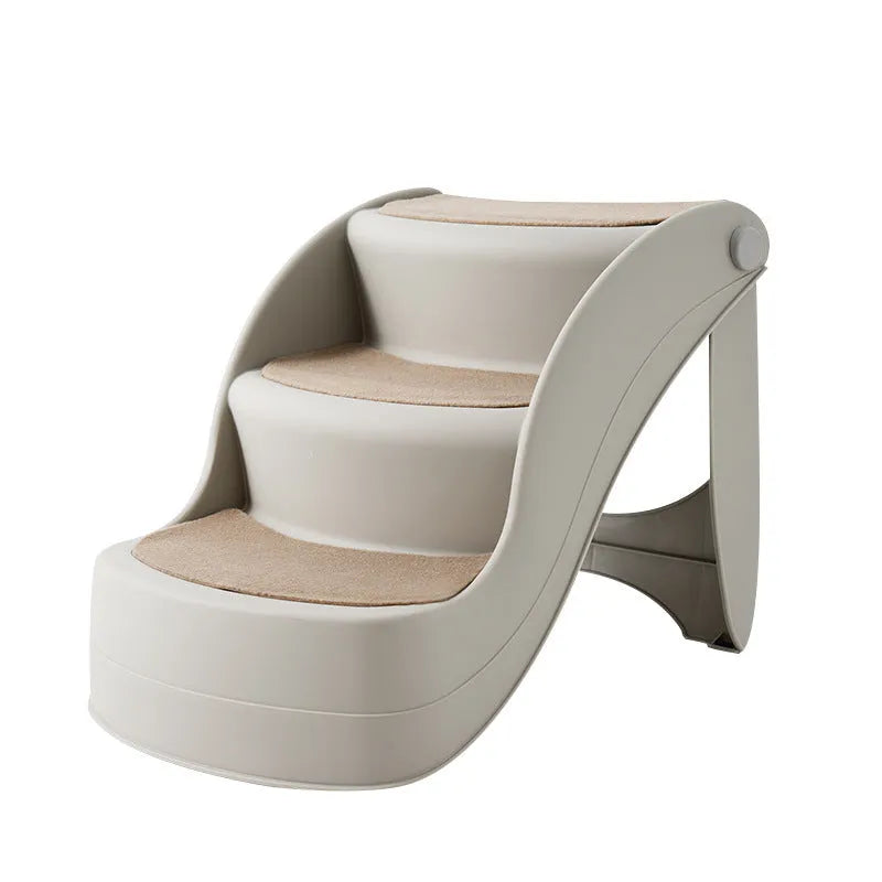 Foldable plastic pet ladder in beige colour with non-slip mat placed against a sofa.