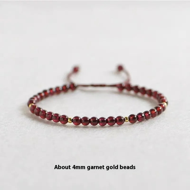 Hand-woven red rope garnet bracelet on a wrist, showing flexible wire and new Chinese style.