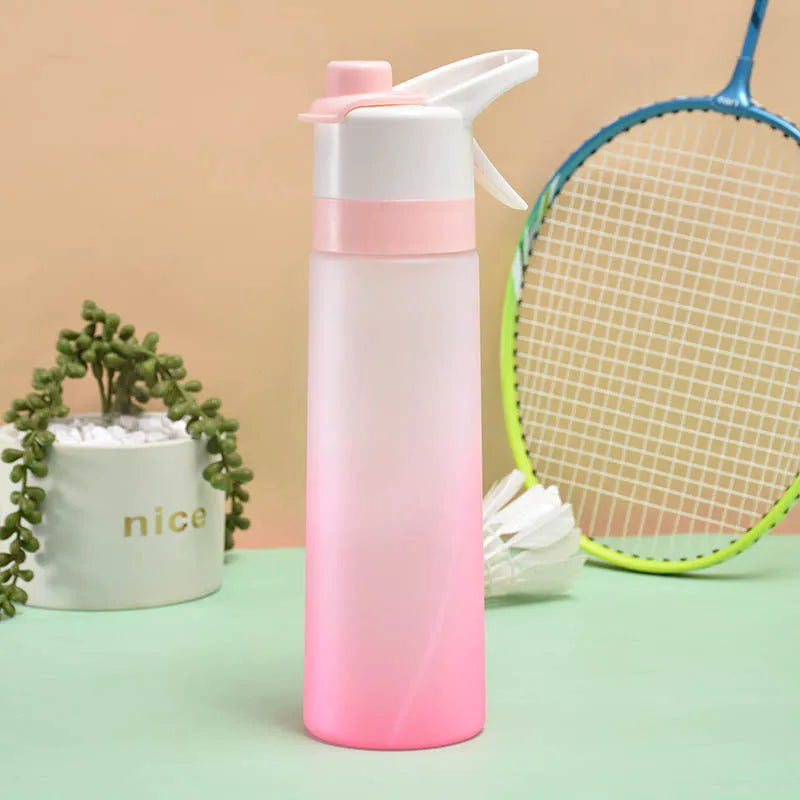 White 700ml plastic spray water bottle with a black handle strap and leakproof lid on a table.
