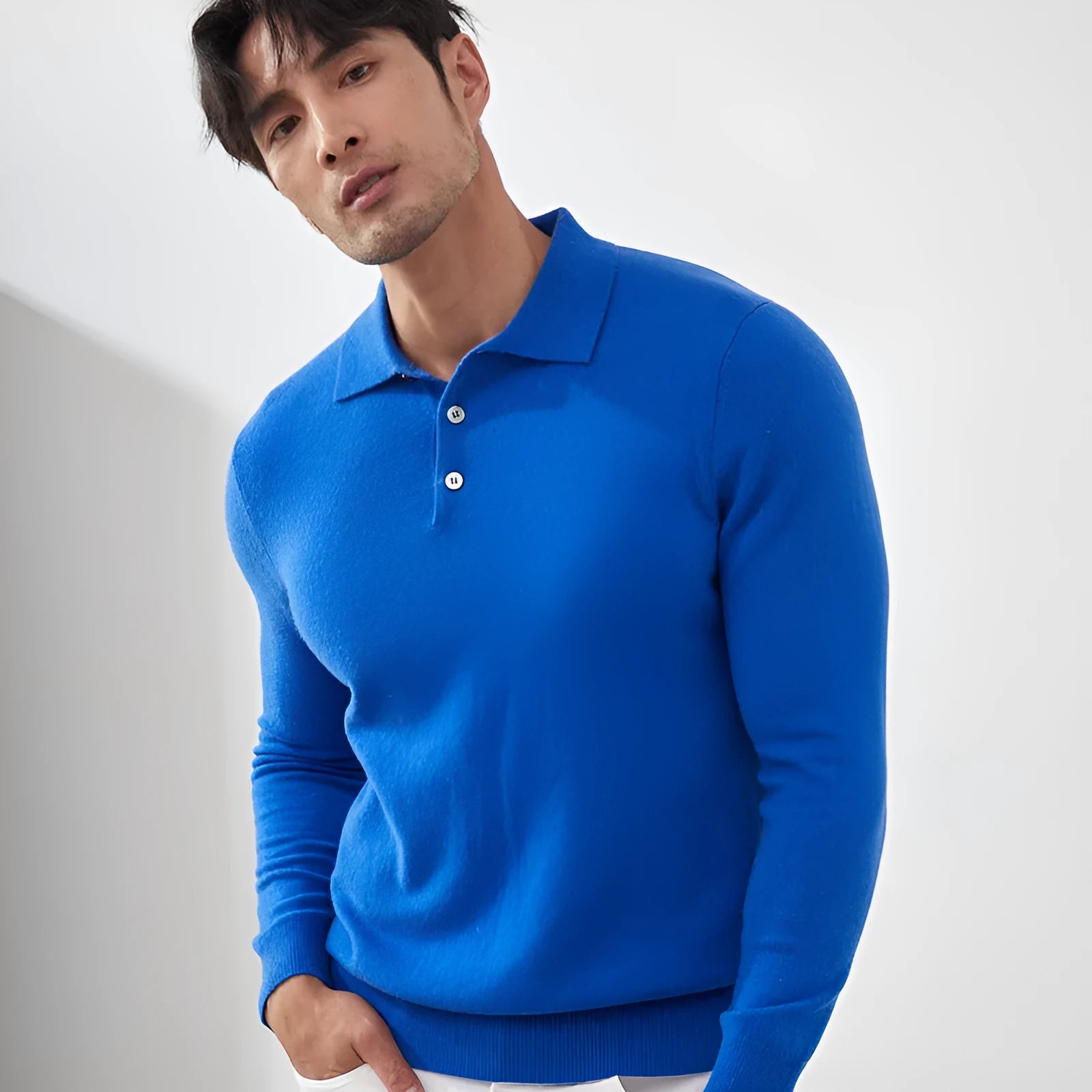 Man wearing a sapphire blue loose-fit cashmere pullover sweater with a polo collar.