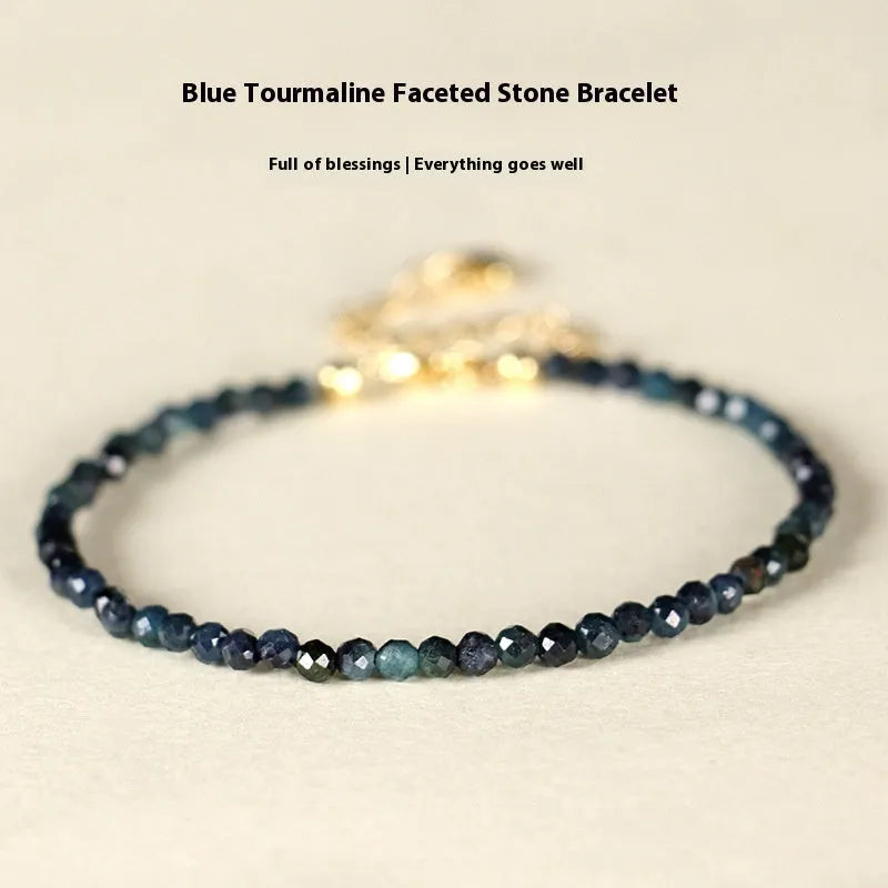 Blue tourmaline gemstone bracelet with 3mm beads and gold spacer details.