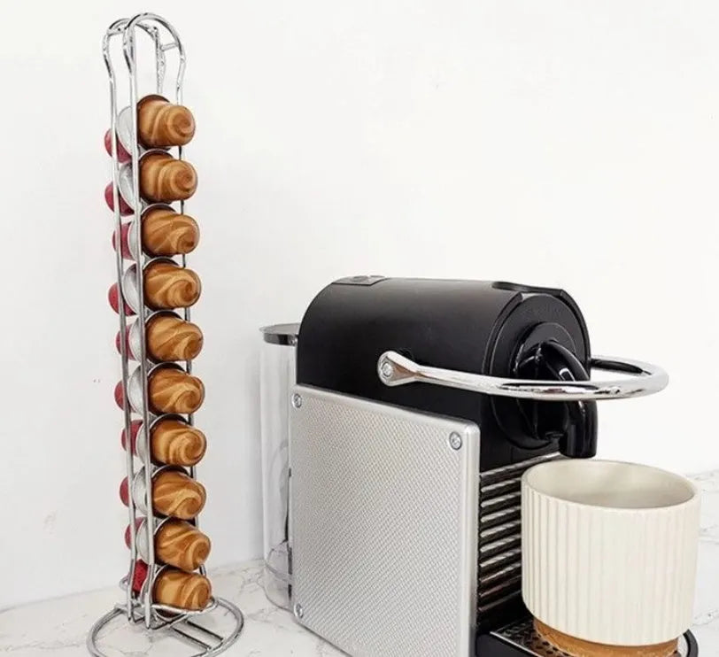 A black wrought iron coffee capsule storage rack holding pods on a kitchen counter.
