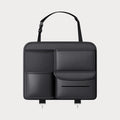 Black leather car seat back storage hanging bag with handle shown behind vehicle seat