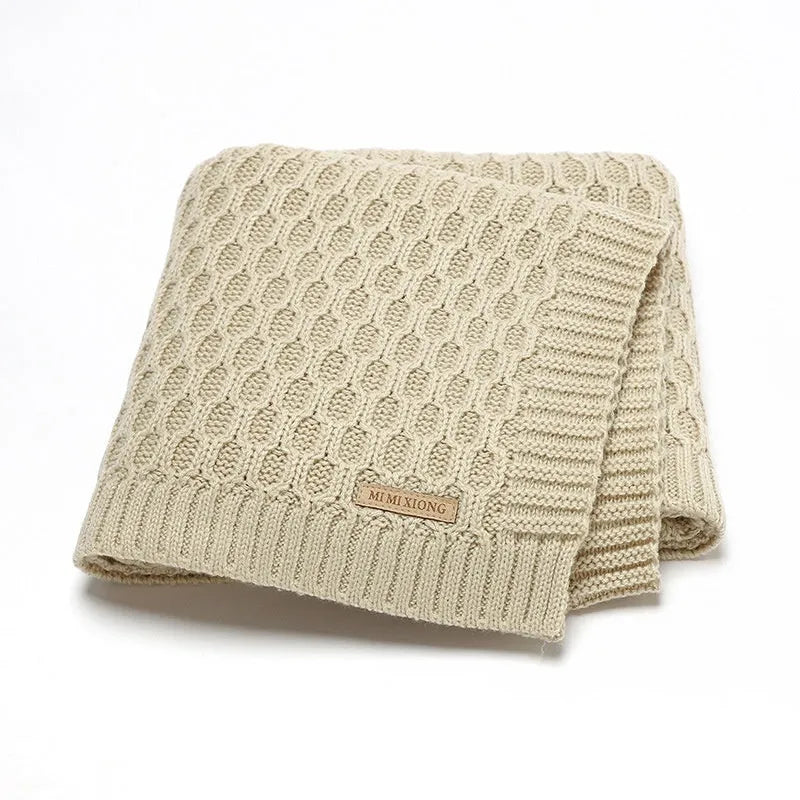 Solid colour acrylic infant blanket with textured lines, shown in a choice of five colours.