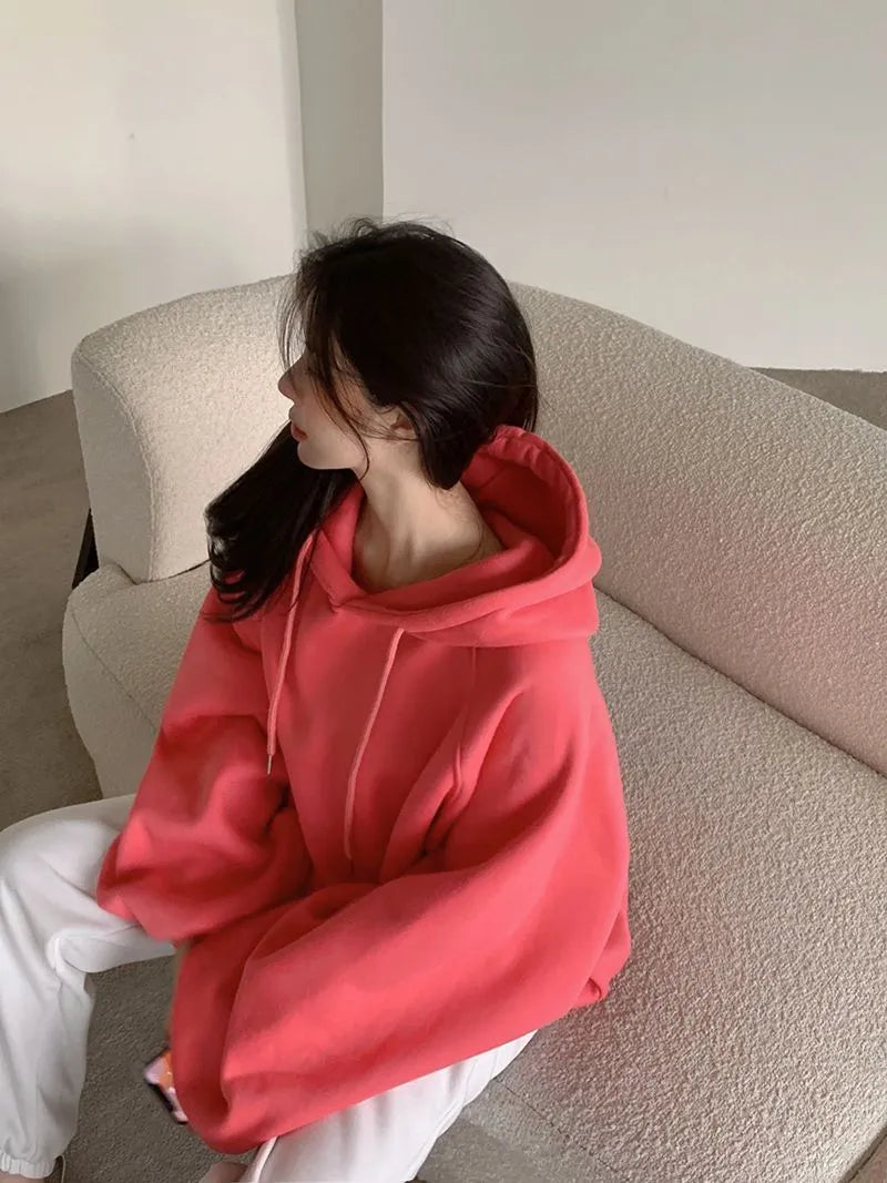 Women's loose watermelon red mulberry silk hooded pullover sweater on a hanger.