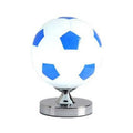 Creative football-shaped glass table lamp with dimmer switch on a desk in a modern living room