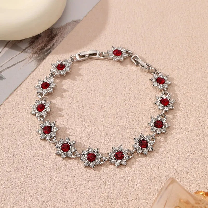 European style electroplated bracelet with flower-shaped coloured gemstones on a metallic chain.