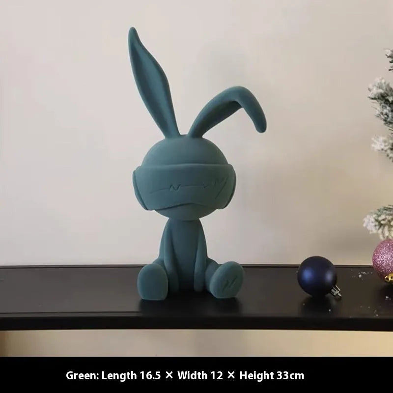 Small green resin suede blindfold rabbit table ornament on a wooden surface