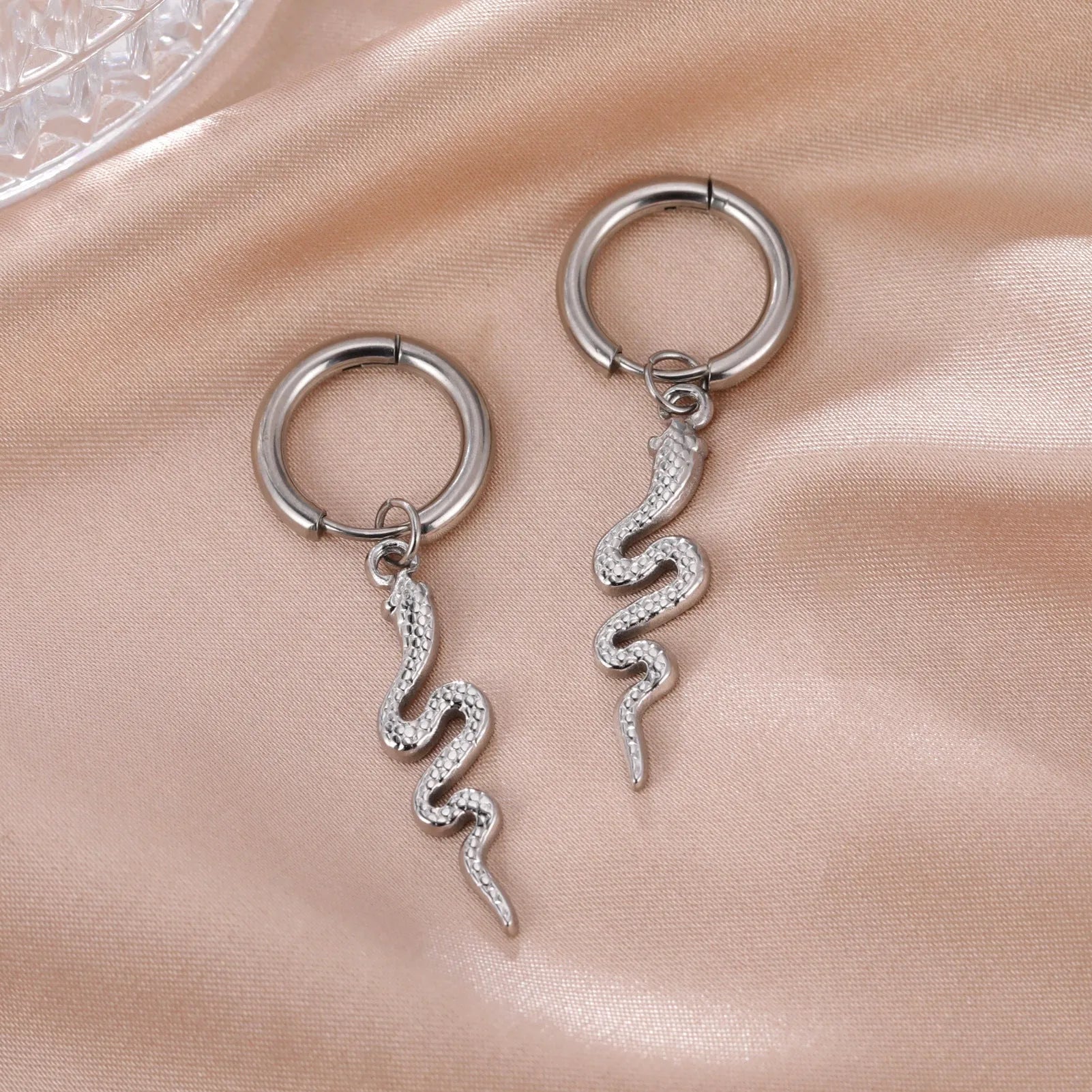 A pair of vintage-style snake-shaped earrings in stainless steel with a gold or steel electroplated finish.