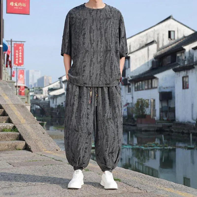 Men's thin knit two-piece set showing short sleeve top and loose cropped trousers in grey.