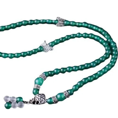 Close-up of a women's multi-strand bracelet with green agate beads on a wrist.