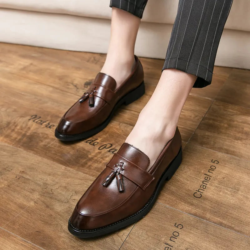 Men's black slip-on business casual shoes with a tassel detail on the front.