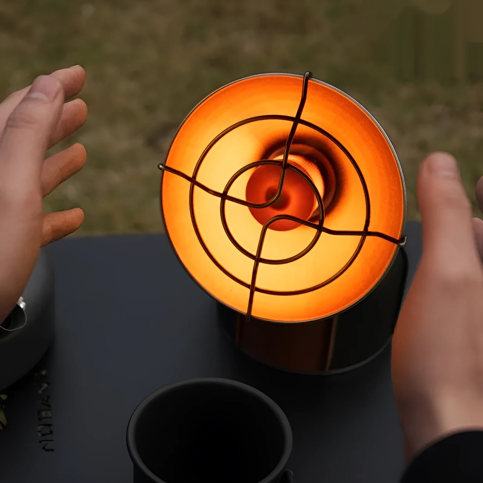 Black and orange portable gas heating stove for camping with automatic ignition.