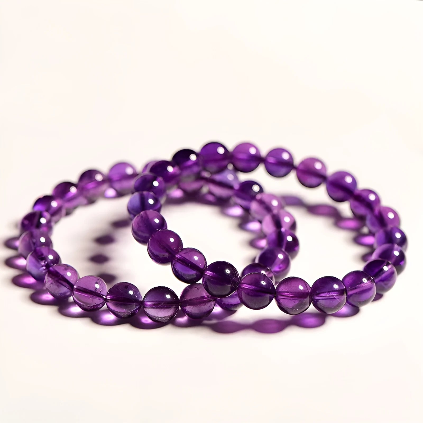 Natural Uruguayan amethyst crystal bead bracelet with polished scattered beads on a white background.