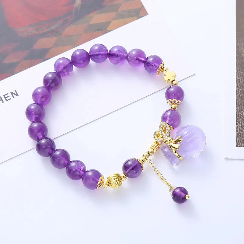 Purple amethyst bracelet with ethnic-style money bag pendant and geometric shapes on wrist