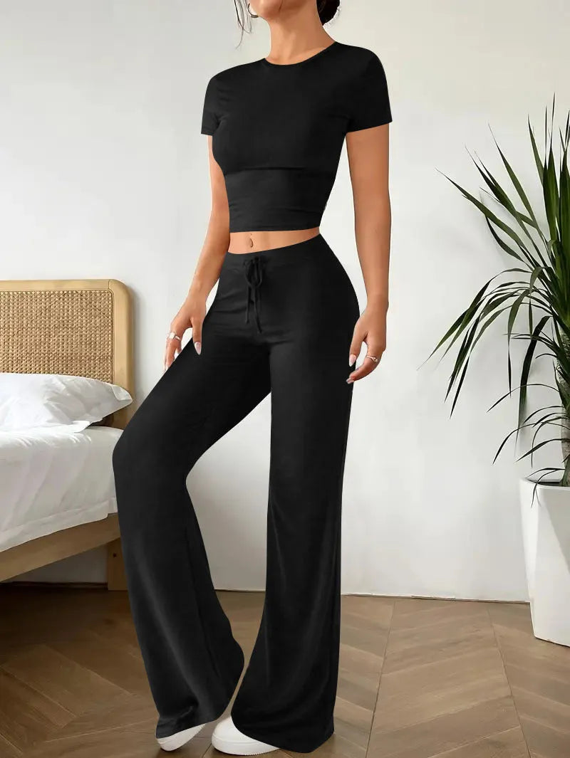 Black high waist trousers and short sleeve t-shirt co-ord suit set on a hanger.