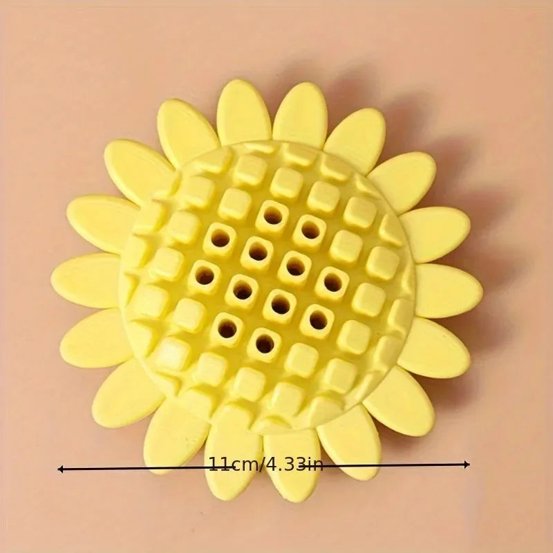 Yellow rubber sunflower dog chew toy with green stem, shown on a white background.