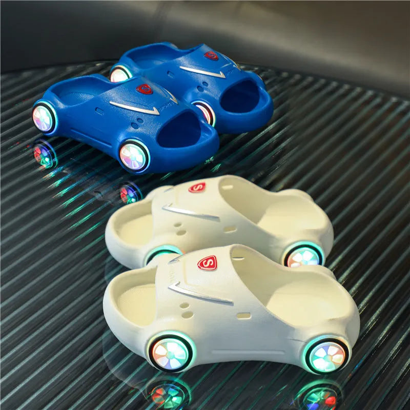 Kids luminous cartoon car slippers flashing blue, with anti-slip sole texture visible.