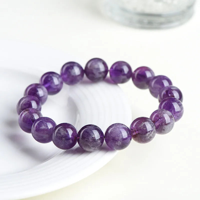 Snow Mountain Feather Amethyst crystal bracelet with scattered geometry beads and Ruyi design on a wrist.