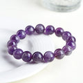 Snow Mountain Feather Amethyst crystal bracelet with scattered geometry beads and Ruyi design on a wrist.