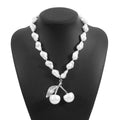 Gold electroplated cherry fruit pendant on an adjustable white pearl chain necklace for women.