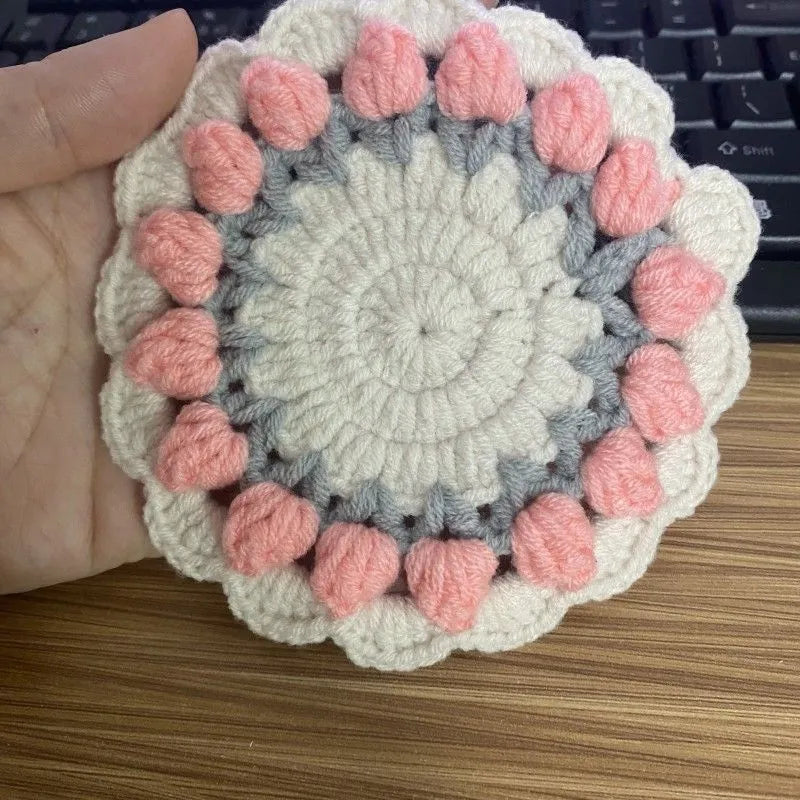 Handmade crocheted flower coaster in cotton and linen yarn, showing pink, purple, red, and yellow colour options.