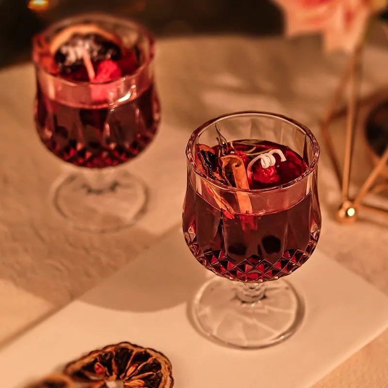 Clear glass wine goblet containing a scented candle with French mulled wine style
