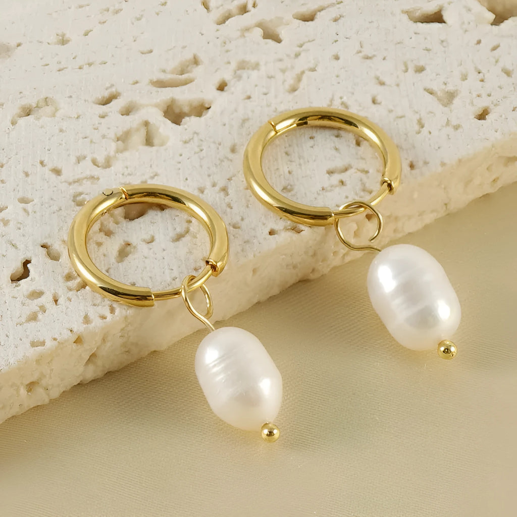 Gold geometric stainless steel earrings with a central white cultured pearl on a post.