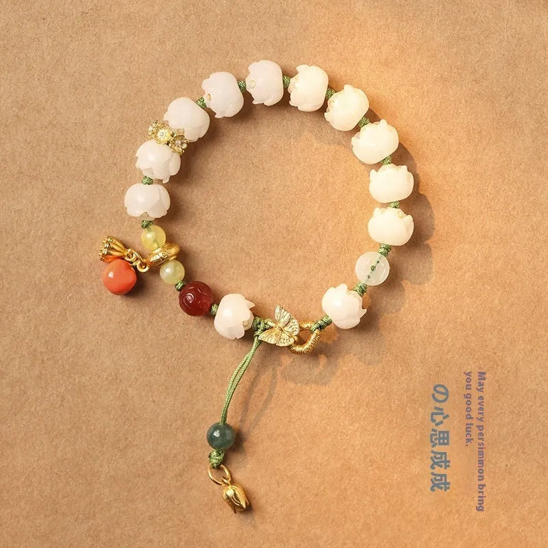 White jade Bodhi bracelet with lotus beads and a large pumpkin bead on an open rope.