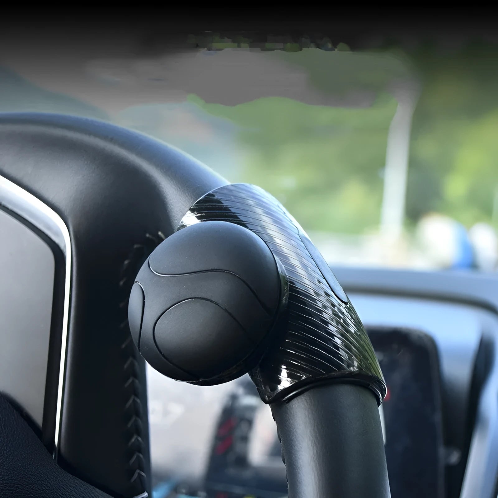Black steering wheel assist ball with silicone grip surface shown on a car steering wheel