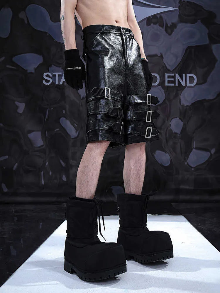 Black men's PU leather cropped pants on hanger showing low waist and flexible spandex material.