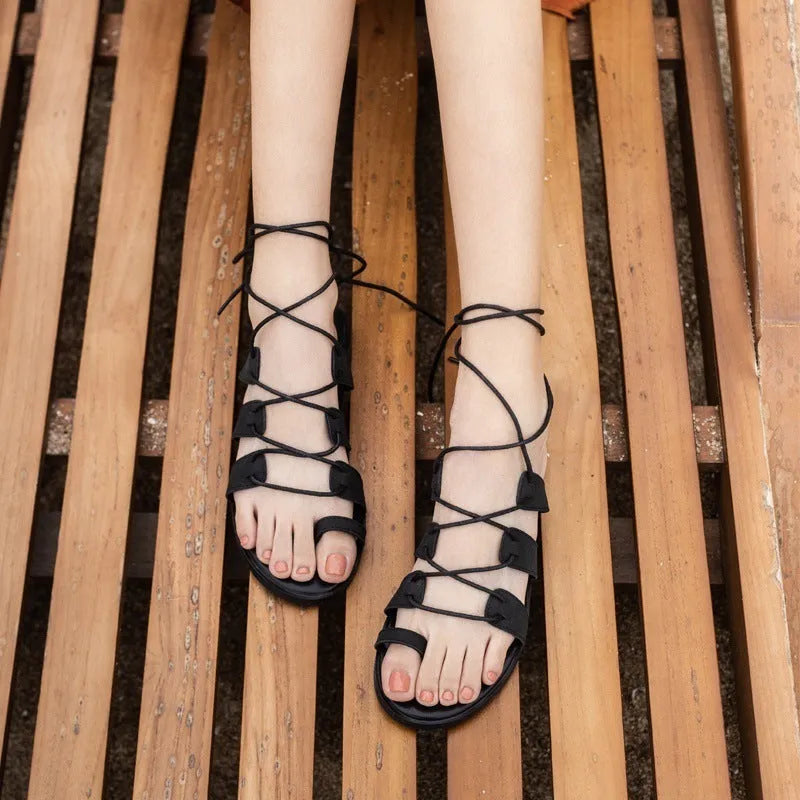 Brown patent leather Roman flip flops for women with flower and bow decorations, rubber sole