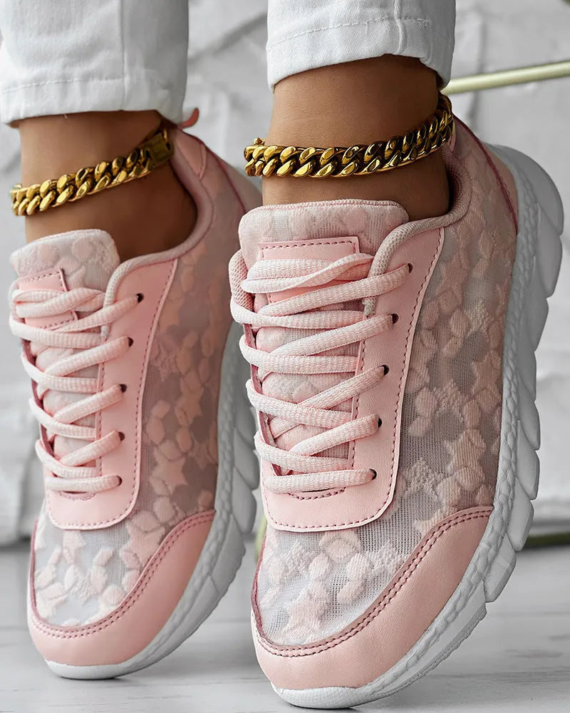 Women's white canvas running shoes with flat heel and round toe on a light background.