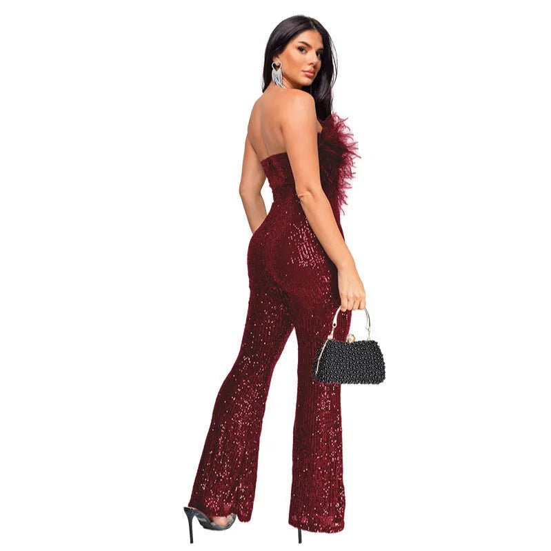 A woman wearing a black sleeveless backless jumpsuit with flared legs and sequin details.