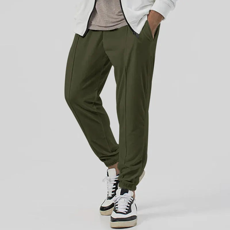 Men's grey loose tapered track sweatpants on a hanger, showing straight-leg design.
