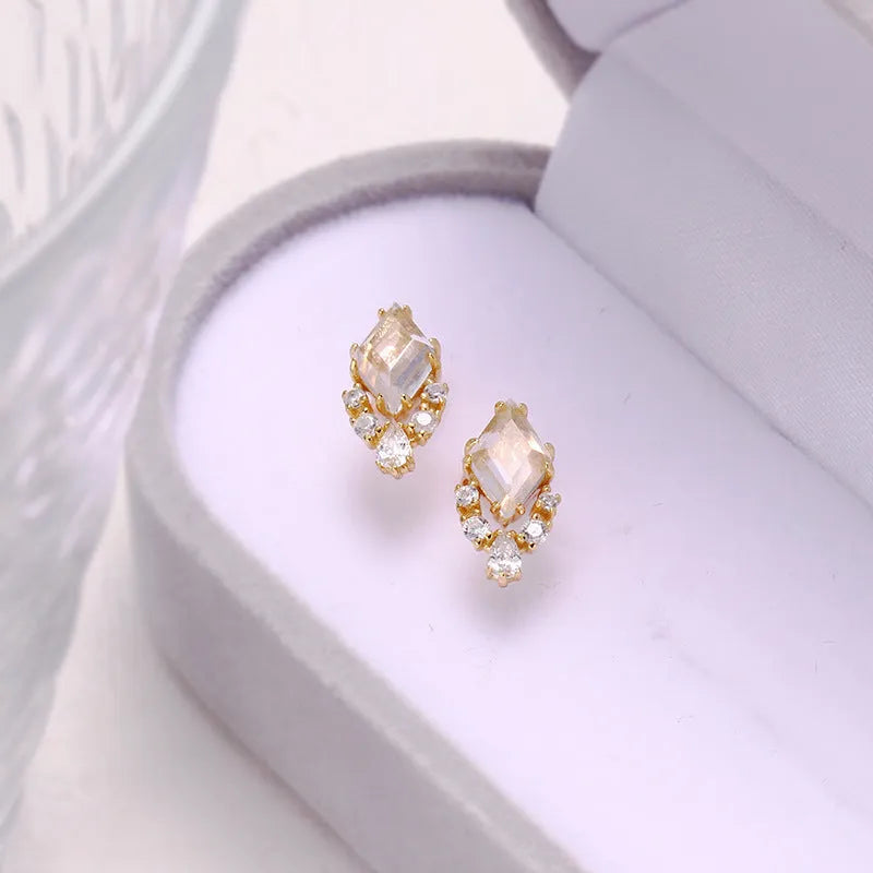 Geometric sterling silver earrings with sweet white crystal studs on white background