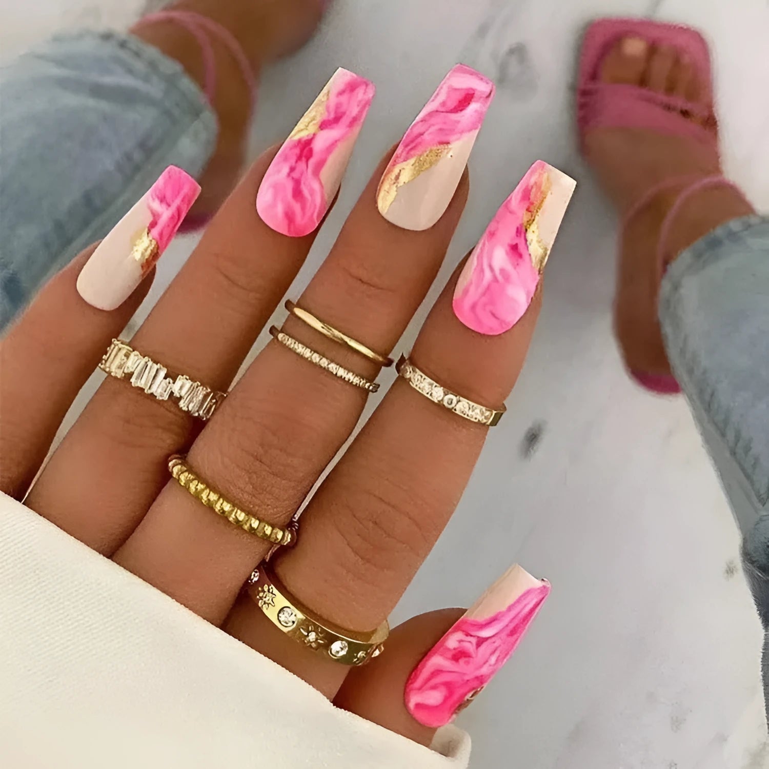 Set of medium-length false nails showing rose, tulip, leopard print, and XINGX patterns with glue.