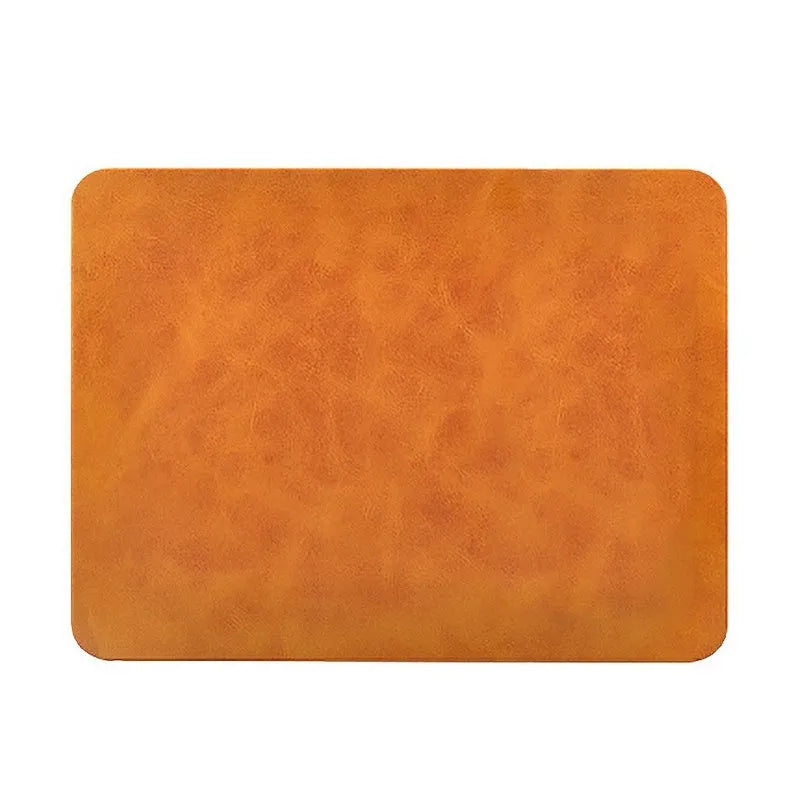 Brown leather wireless charging mouse pad with Micro USB cable on a wooden desk.