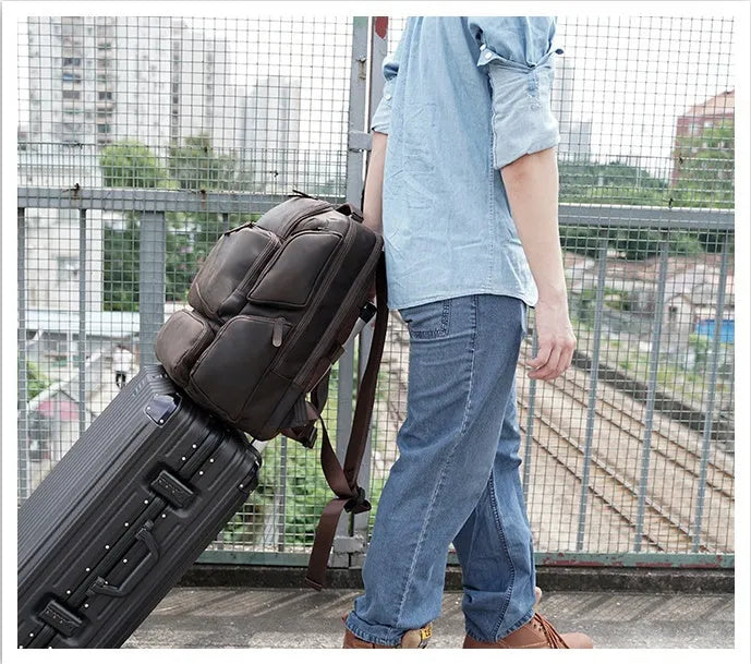 Dark brown retro crazy horse leather backpack for men open to show 17-inch laptop compartment and internal organisers.