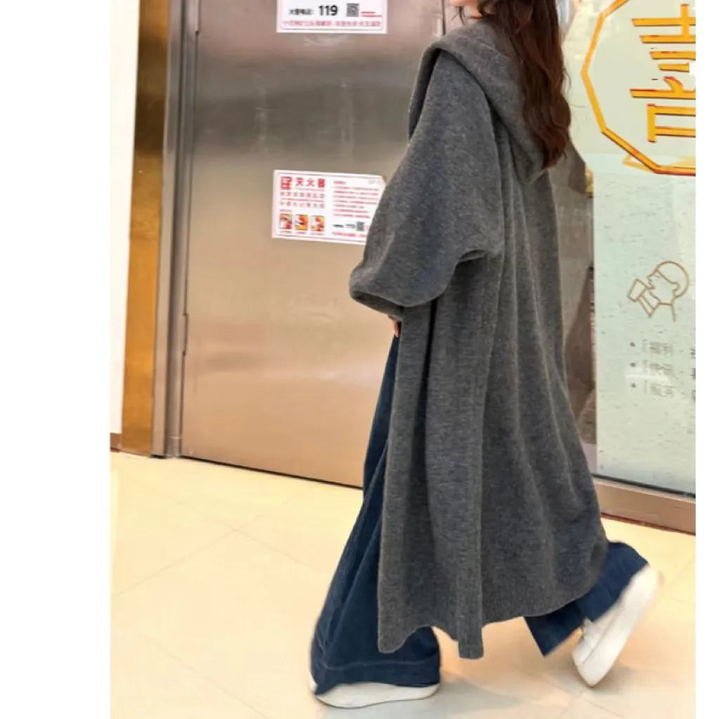 Women's long brown hooded knitted cardigan with a below-the-knee length and loose fit.