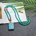 Hand-woven turquoise mesh flower lucky pendant necklace on a ball bead chain.
