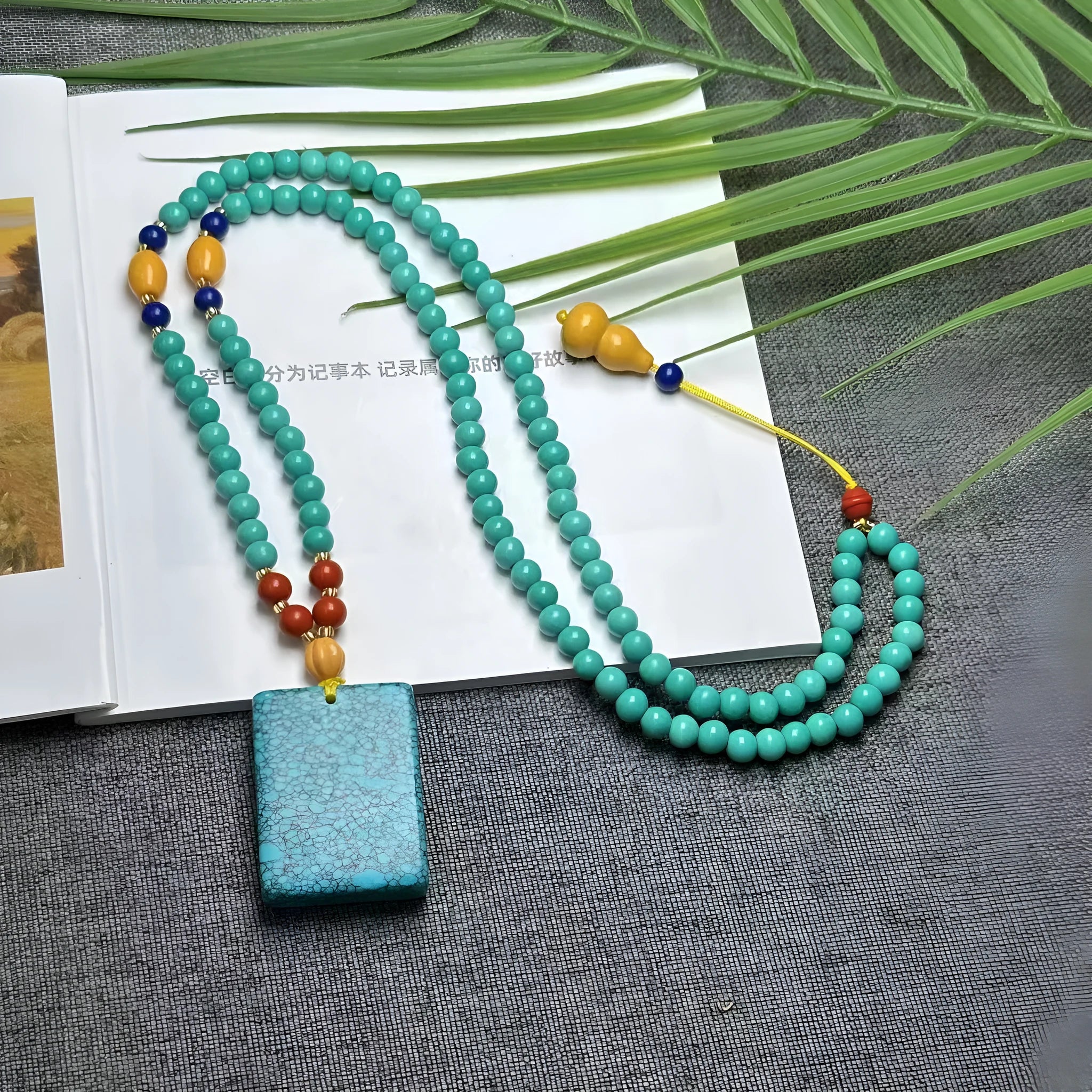 Hand-woven turquoise mesh flower lucky pendant necklace on a ball bead chain.