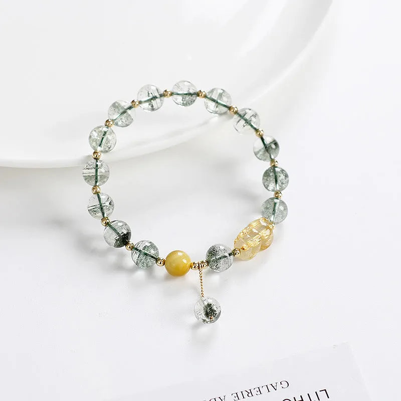 Green phantom quartz bracelet with 8mm geometric beads and gold rutile inclusions on wrist