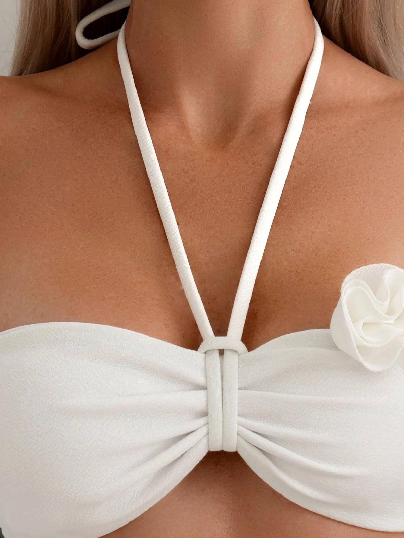 White halter neck lace-up bikini with three-dimensional floral embroidery and brief bottoms.