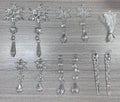 Ten clear transparent acrylic ice cone Christmas tree ornaments with white ribbons on green branches.