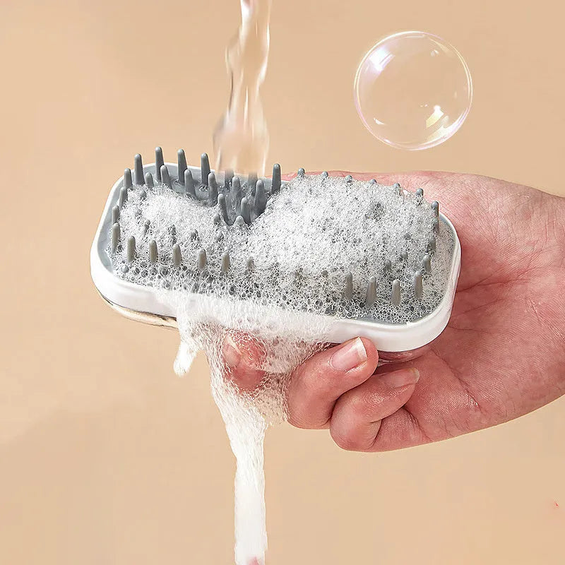 Grey silicone pet bath brush with flexible bristles and non-slip handle for washing dogs and cats.