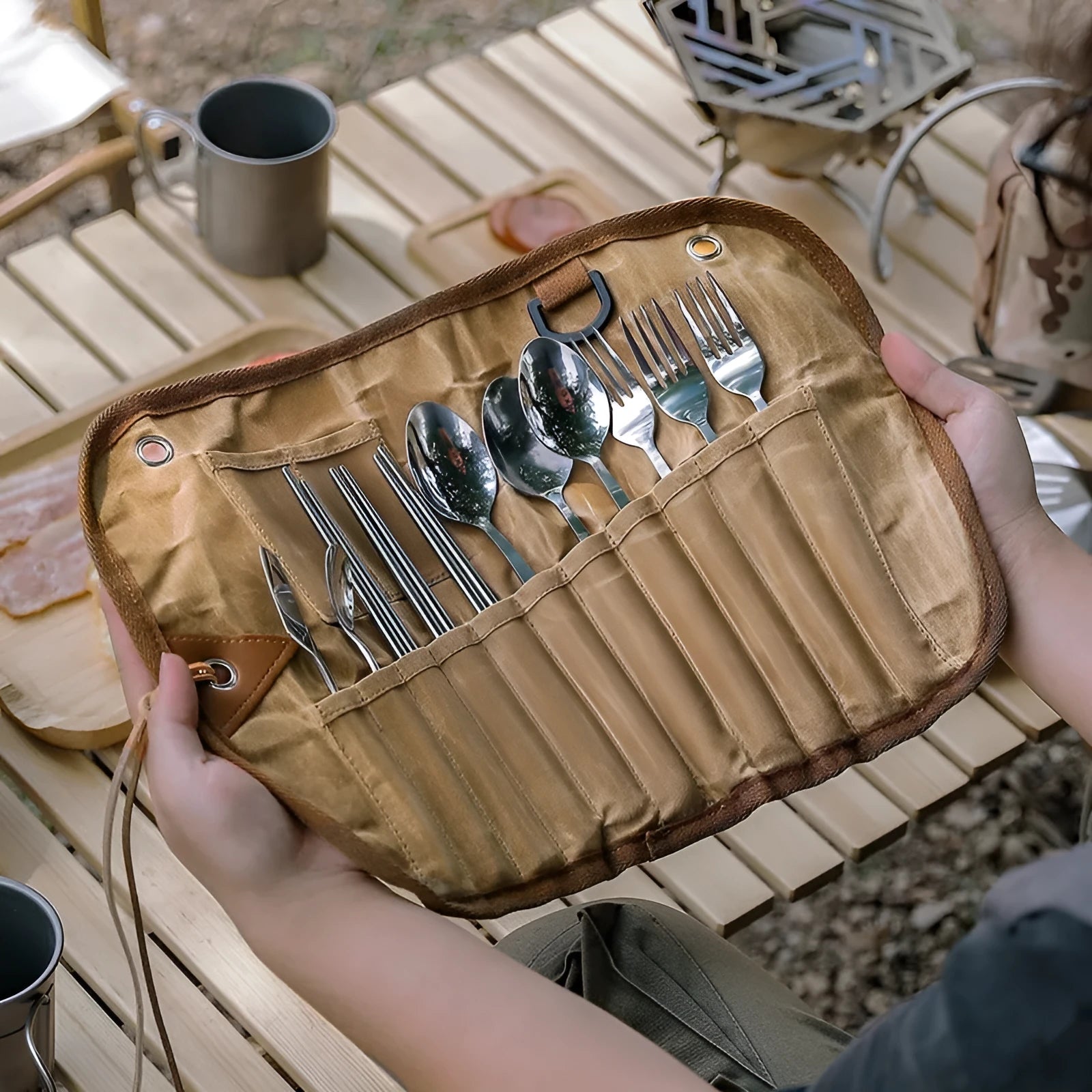 Waxed canvas portable storage bag containing a wooden handle knife, fork, spoon, butter knife, coffee spoon, and chopsticks.
