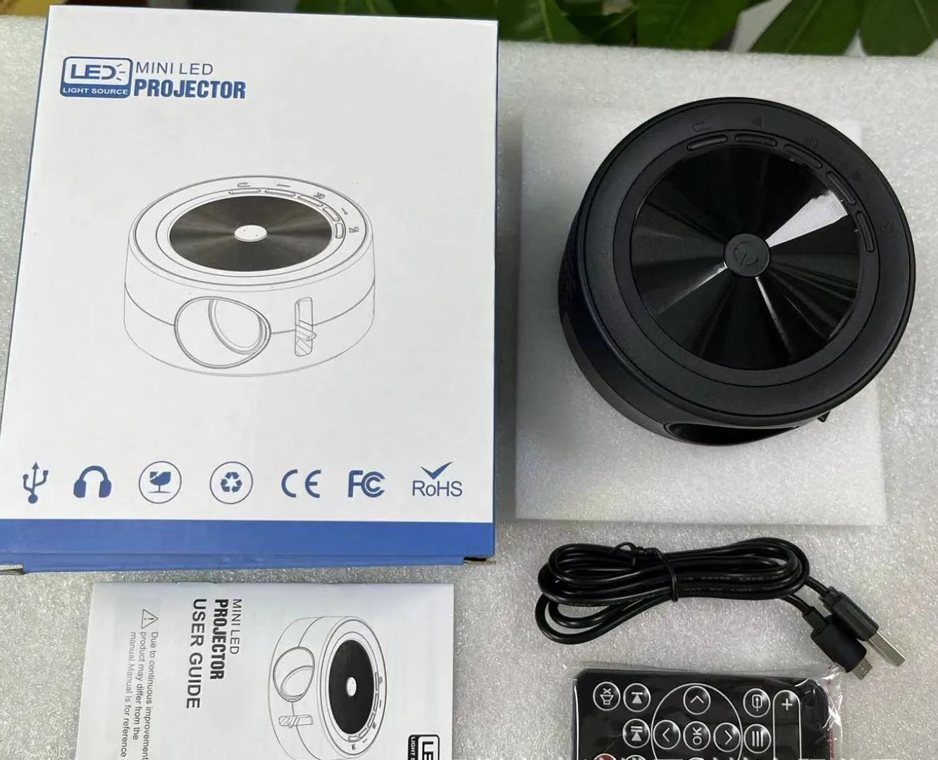 YT200 compact LED projector in black, white, yellow and white, or blue and white colours with remote control