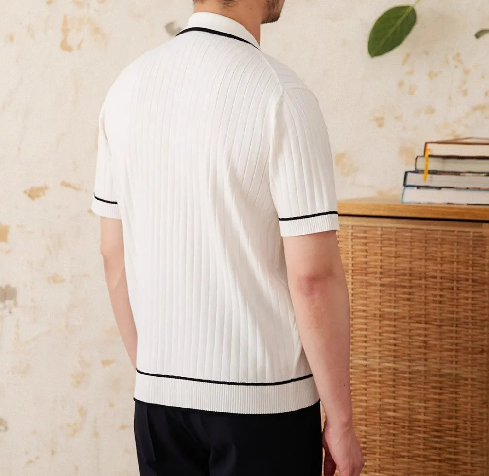 A black lapel short-sleeved knit polo shirt laid flat, showing the collar and slim fit.